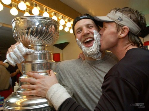 Kirk Maltby, left, gets interupted from shaving his beard to get a kiss from Kris Draper.  cup final and locker room..Stanley cup winners The Detroit Red Wings.....The Detroit News/DAVID GURALNICK